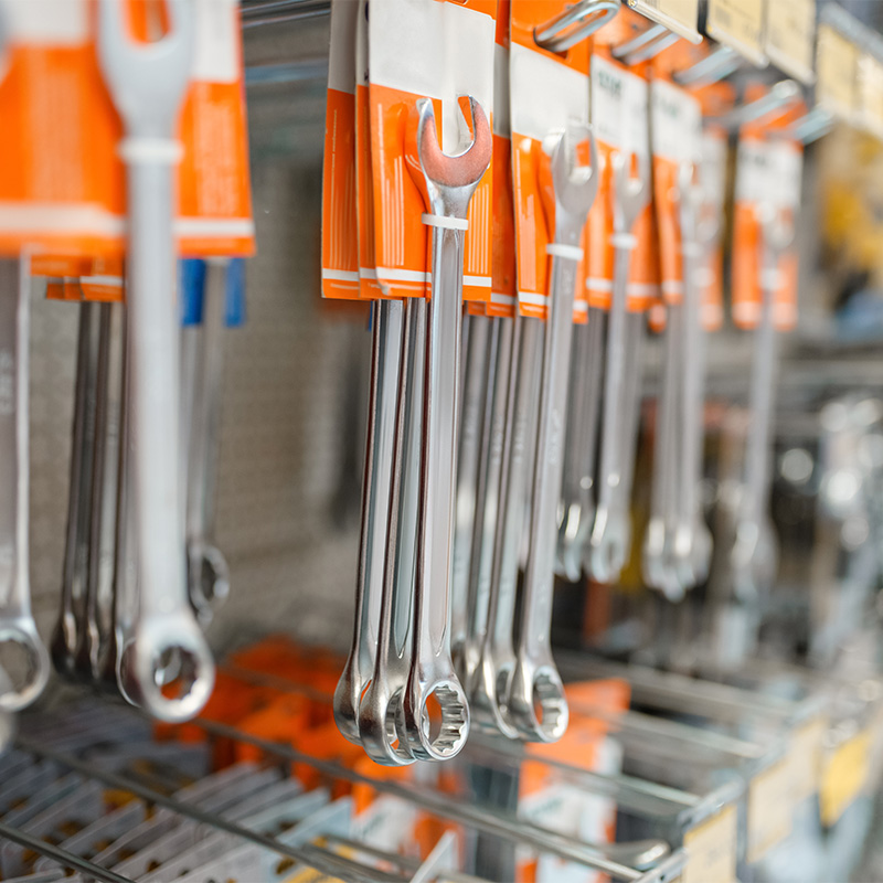 Rows of wrenches in hardware store closeup view, nobody. Metal tools and equipment on the shelf in diy